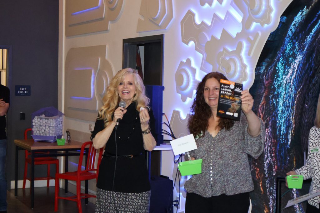 Two women giving out raffle prizes at a Chamber Mixer event at Cafe Dobe.