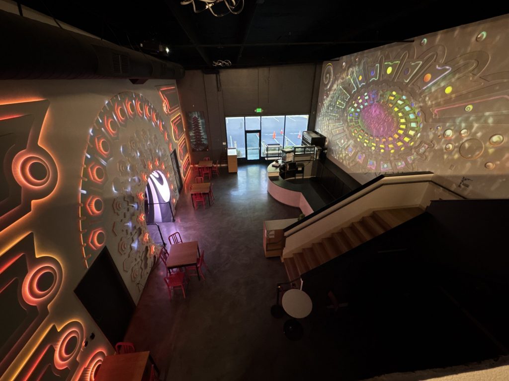 A wide shot of the portal and projector walls of the cafe from Upstairs.